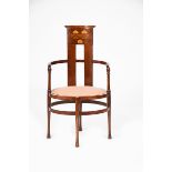 An Arts and Crafts mahogany armchair, the oval seat with curved back inlaid with Art Nouveau