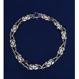 A Georg Jensen silver link necklace with lapis clasp, ten panels cast in low relief with