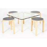 A modern birch ply table and four Artek stacking stools designed by Alvar Aalto, square section