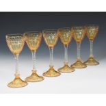 A set of six Stuart amber and clear glass wine glasses, amber glass shallow foot support clear