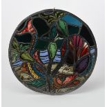 An Arts and Crafts stained glass roundel, decorated with a pike swimming amongst water lily flowers,