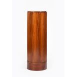 A mahogany fluted cylindrical pedestal, on drum base, 116cm. high, 38.5cm. diam.