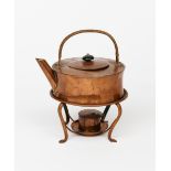 A Keswick School of Industrial Arts copper kettle on a stand, drum form with over-slung handle,