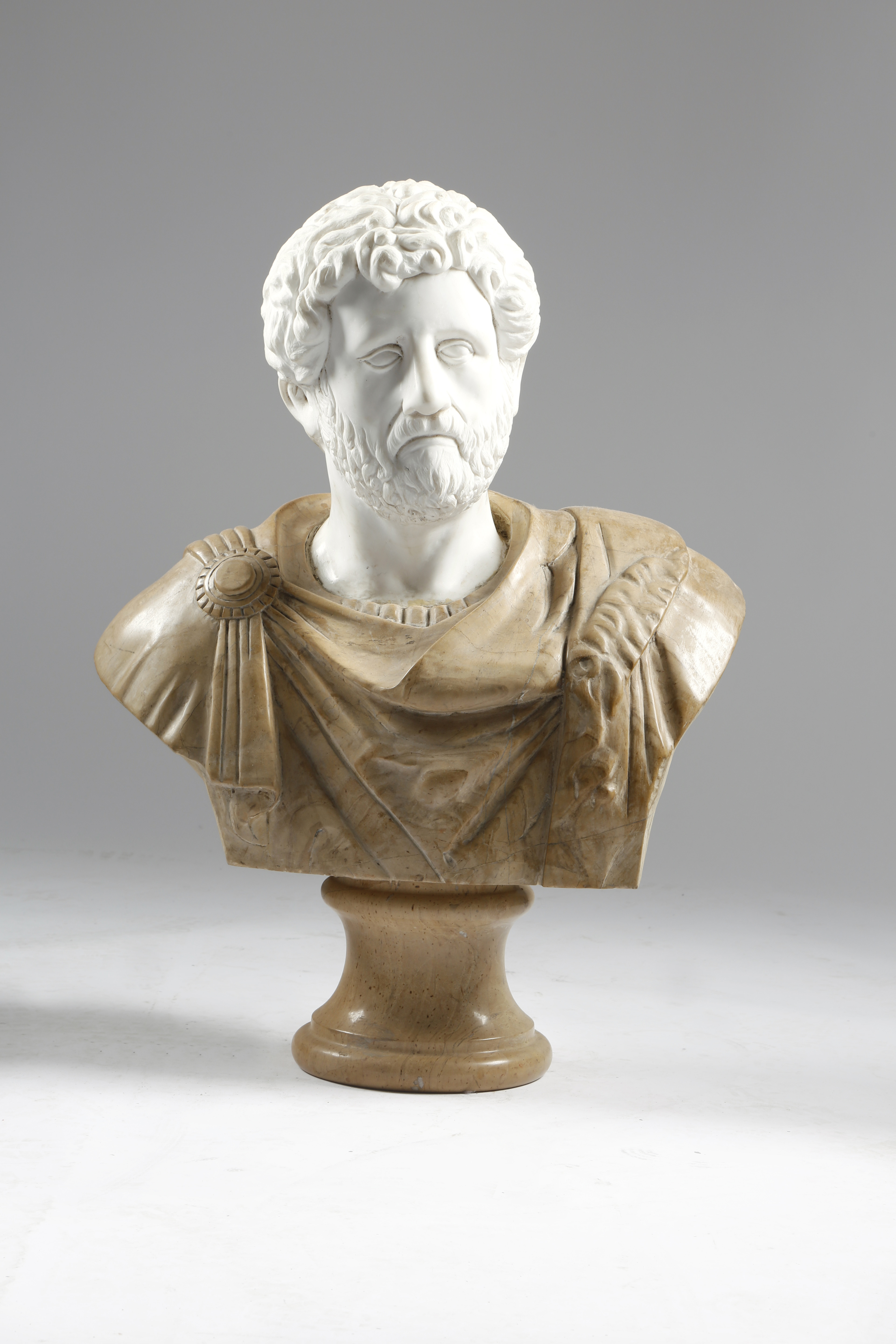 AFTER THE ANTIQUE. A CARVED MARBLE BUST OF THE ROMAN EMPEROR COMMODUS 20TH CENTURY his toga sculpted