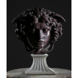 AFTER THE ANTIQUE. AN ITALIAN PORPHYRY RELIEF MASK OF THE MEDUSA RONDANINI