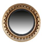 A GILTWOOD CONVEX MIRROR IN REGENCY STYLE 19TH CENTURY the circular plate in an ebonised reeded slip