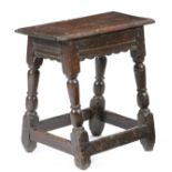 AN OAK JOINT STOOL MID-17TH CENTURY the top with thumbnail carved edges, above a moulded frieze with