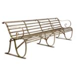 A WROUGHT IRON GARDEN BENCH LATE 19TH CENTURY with a slatted back and seat, with scroll supports