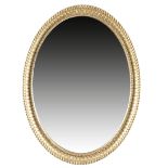 A GEORGE III GILTWOOD OVAL WALL MIRROR c.1790 the oval plate within a beaded and fluted moulded