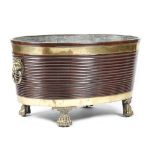 A LARGE MAHOGANY AND BRASS BOUND WINE COOLER IRISH REGENCY STYLE the rim decorated with shells, with