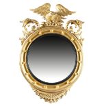 A GILTWOOD WALL MIRROR IN REGENCY STYLE 19TH CENTURY the circular plate within a reeded slip and a