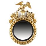 A REGENCY GILTWOOD CONVEX WALL MIRROR EARLY 19TH CENTURY the circular plate within a reeded slip,