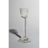 A cordial glass, c.1740-50, the small rounded funnel bowl engraved with a large sunflower, raised on