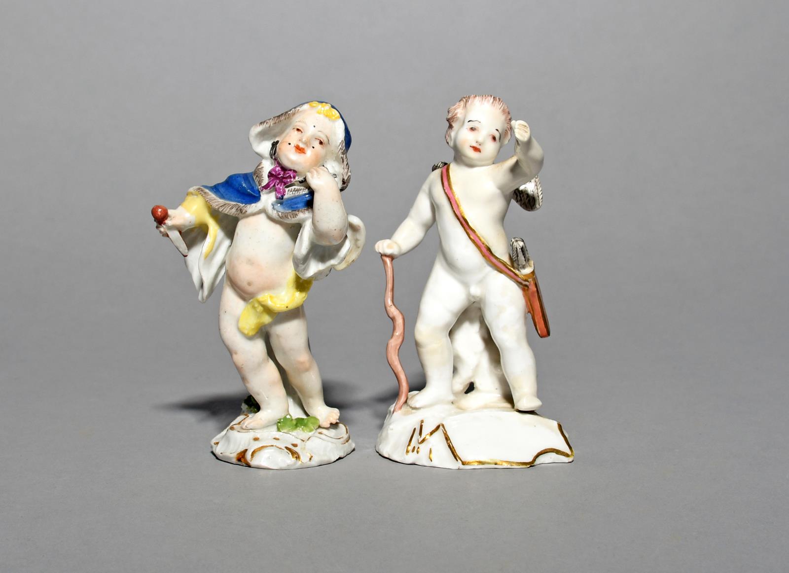 A Meissen figure of Cupid in Disguise, mid 18th century, wearing a fur-lined blue hooded cloak,