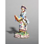 A Bow figure of a huntress, c.1760-65, holding a pistol in her right hand, a small bird perched on