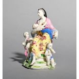A Bow figure group emblematic of Charity, c.1760, modelled as a mother seated and breast-feeding