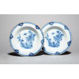 A pair of delftware soup plates, c.1760, each painted in blue with a bird in flight above peony