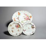 Two Chelsea plates and a dish, c.1753-56, the plates painted with a flower spray and single