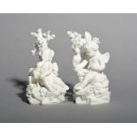 A pair of Derby biscuit porcelain figures of putti, c.1780, each seated on rockwork beneath an oak