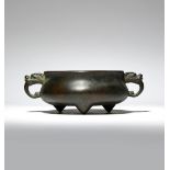 A CHINESE BRONZE TRIPOD INCENSE BURNER QING DYNASTY The compressed body flanked by two loop