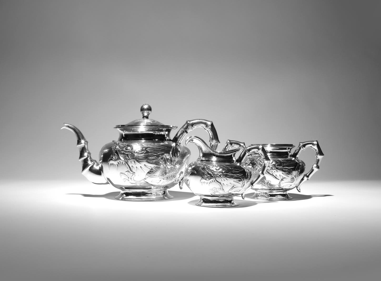 λ A CHINESE SILVER THREE-PIECE TEA SET 19TH CENTURY Comprising: a teapot with a hinged cover, a