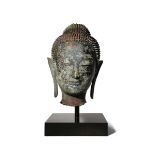 A THAI BRONZE HEAD OF BUDDHA 17TH CENTURY Cast with a serene expression, the face framed by his