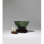 A CHINESE SPINACH-GREEN JADE BOWL AND A PALE CELADON JADE 'BITTER MELON' CARVING 18TH CENTURY The