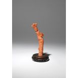 A CHINESE CORAL CARVING OF A LADY 19TH CENTURY The slender figure stands dressed in long robes
