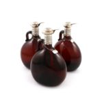 A set of three Victorian silver-mounted brown glass spirit decanters, the mounts by Henry Atkin,