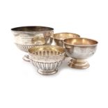 A collection of four silver trophy bowls, comprising: one of circular form, with fluted