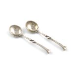 By Omar Ramsden, a pair of Arts and Crafts silver salt spoons, London 1927, square seal-top finials,