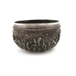 A Burmese silver rice bowl, unmarked, circular form, embossed and chased with figural scenes in