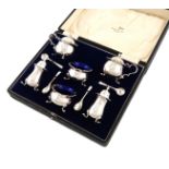 A six-piece silver condiment set, by Walker and Hall, Birmingham 1932, circular bellied form, wavy-