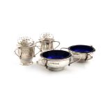 By A. E. Jones, a pair of Arts and Crafts silver pepper pots and a pair of salt cellars,