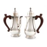 A pair of silver cafe au lait pots, by Mappin and Webb, Sheffield 1938, baluster form, side scroll