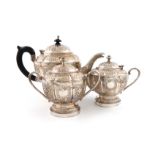 A three-piece Indian silver tea set, marked 'Pure Silver', lobed circular form, chased foliate