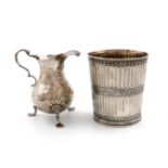 A George II silver cream jug, maker's mark W?, London 1744, baluster form, embossed with animals and