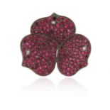 A ruby and diamond flower head pendant, pave-set with circular-cut rubies and a diamond to each