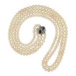 A two-row cultured pearl necklace, set with a sapphire and diamond scroll clasp in white gold,