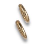 A pair of gold hoop earrings by Cartier, the hollow gold hoop clips with invisible spring-loaded