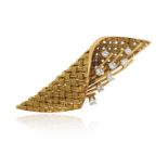 A stylised gold basket brooch, the woven gold fabric containing a stylised floral sprig decorated