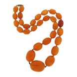 A single-row amber bead necklace, the beads graduate from 12 - 28mm, 62cm long, 90g total