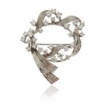 A diamond scroll brooch, set with round brilliant-cut diamonds in textured white gold, 4cm high