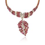 A ruby and diamond-set gold necklace, alternately-set with rubies and diamonds, suspending a leaf-