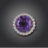 An Edwardian amethyst and diamond brooch, the circular-cut amethyst set within a surround of old