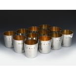 A set of twelve Gerald Benney silver gilt beakers, flaring cylindrical form, stamped marks, AGB