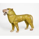 A carved wood model of a lioness, modelled standing, painted in yellow and black, unsigned, 56cm.