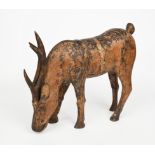 A carved wood model of a deer, modelled standing with head down, remains of paint, unsigned, 55cm.