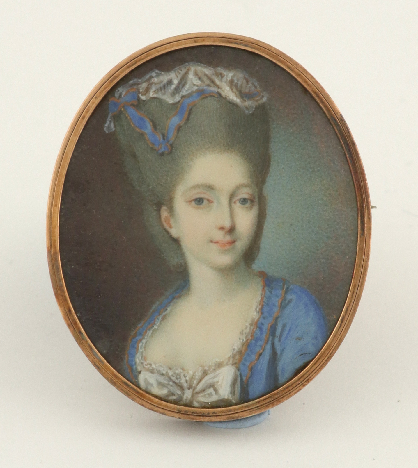 λFrench School 18th Century Portrait miniature of a young lady, wearing a blue dress, and lace cap