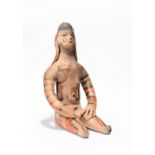 An Amazonian seated female figure Brazil earthenware with red and black decoration, 12cm high.